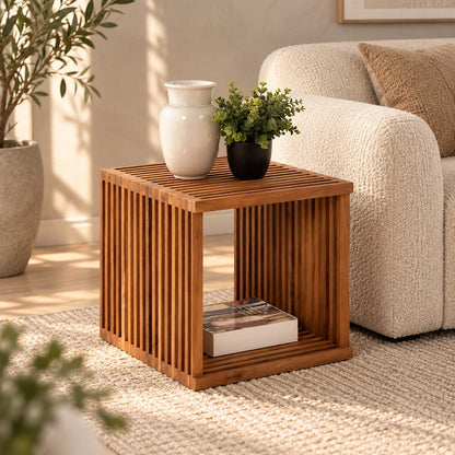 Quadratischer Beistelltisch CUBE aus massivem Teakholz mit Lamellenstruktur neben einem cremefarbenen Sofa in einem hellen Wohnzimmer.